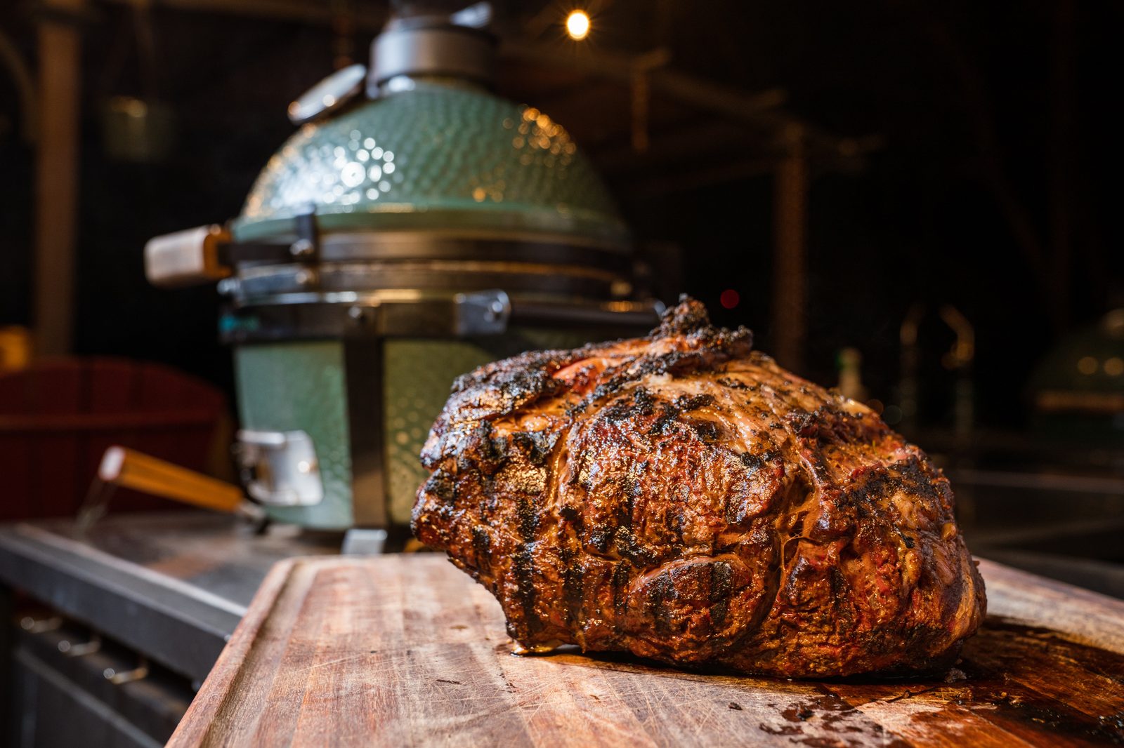 Prime rib roasting in front of a Big Green Egg